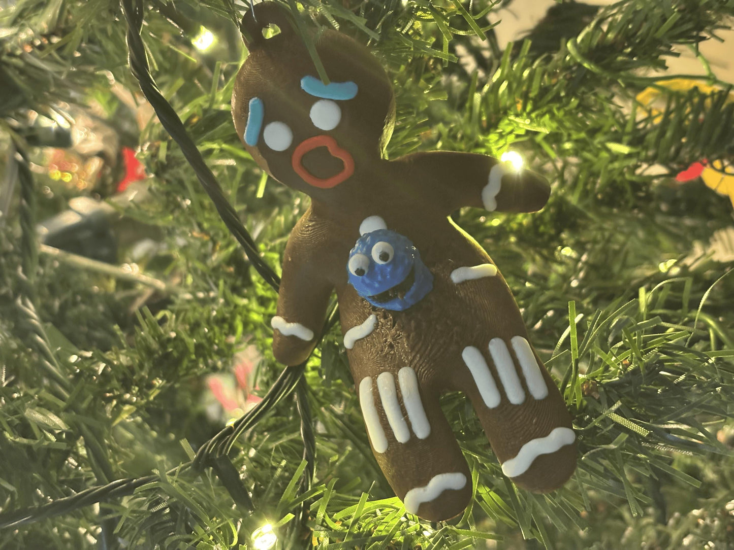 Side angle of gingerbread chestburster ornament showing blue alien creature and PLA print texture