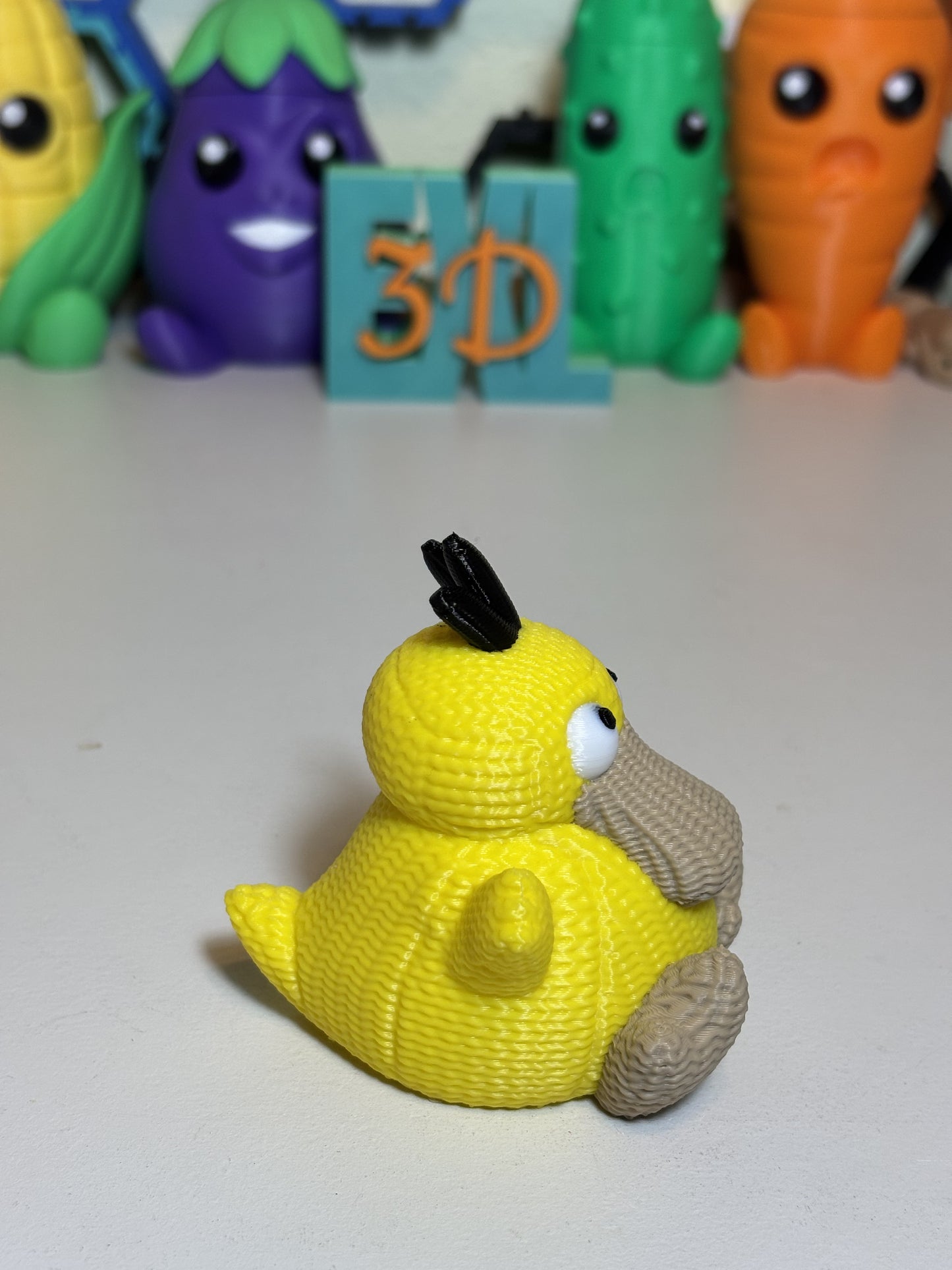 Side angle of faux knit Psyduck collector figurine on neutral background