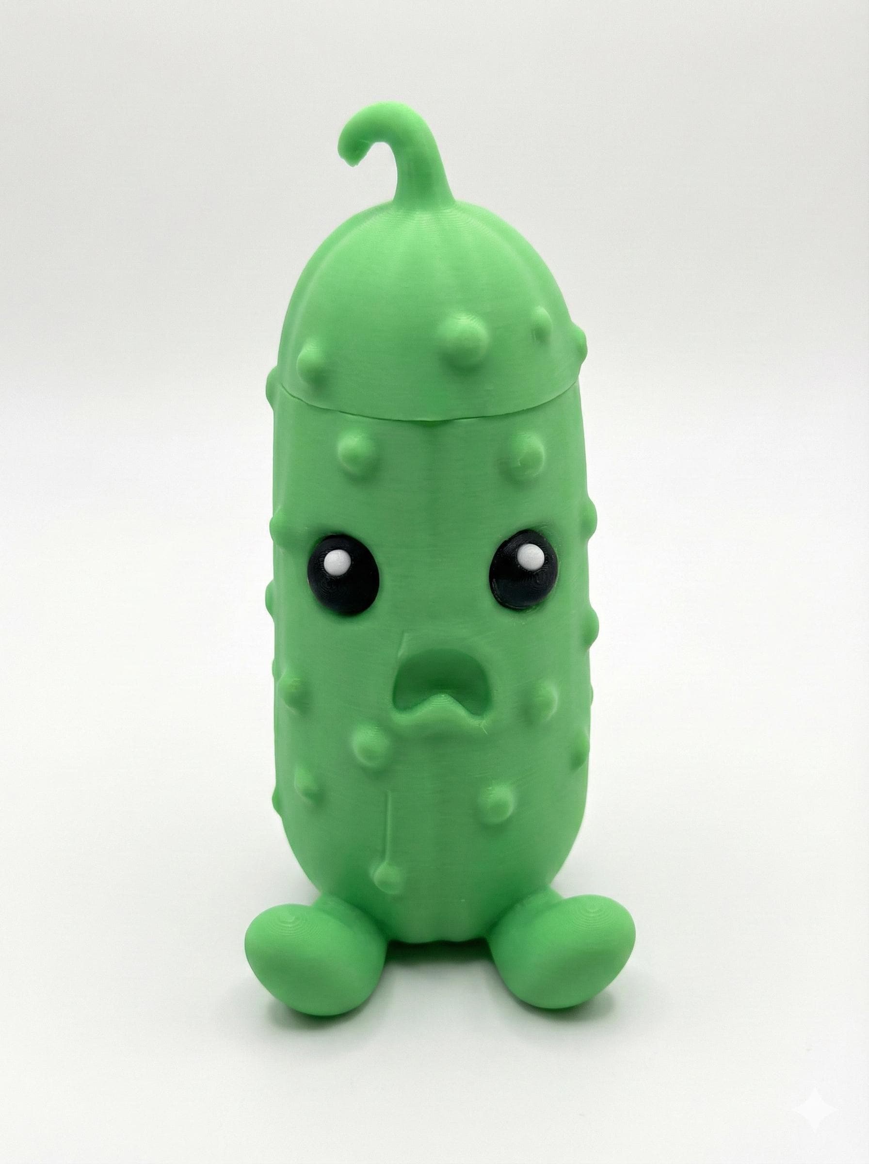 Vibrant green 3D printed pouty pickle figurine with hidden compartment open on desk