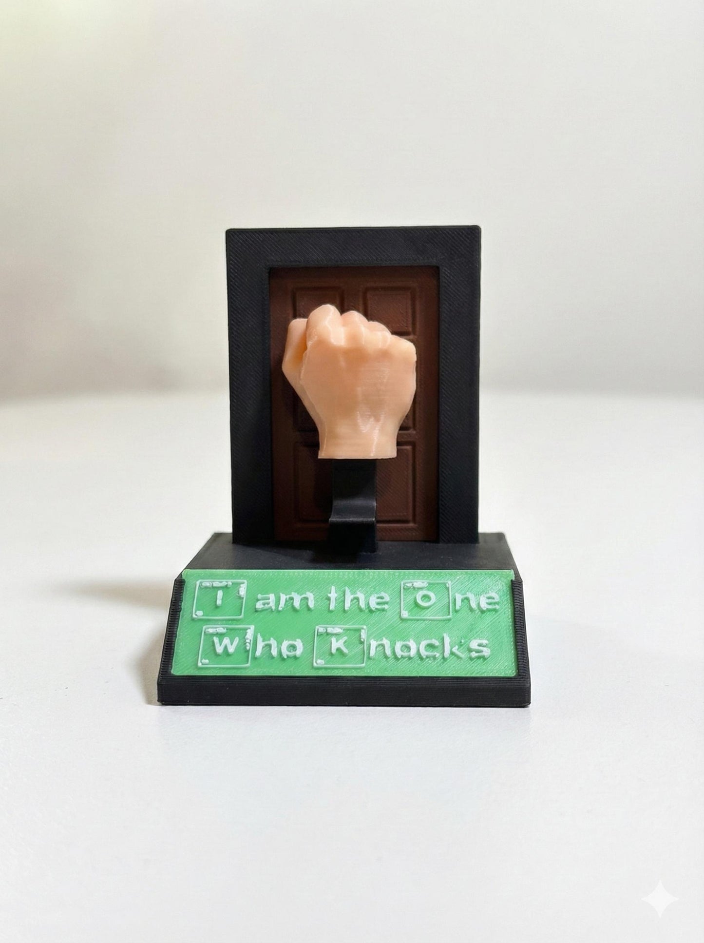 Close-up of periodic table sign plate on matte black desk toy base