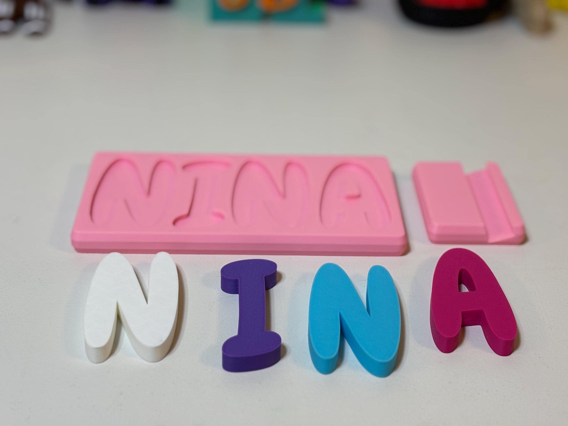 Overhead flatlay of all letters removed from personalized name puzzle base