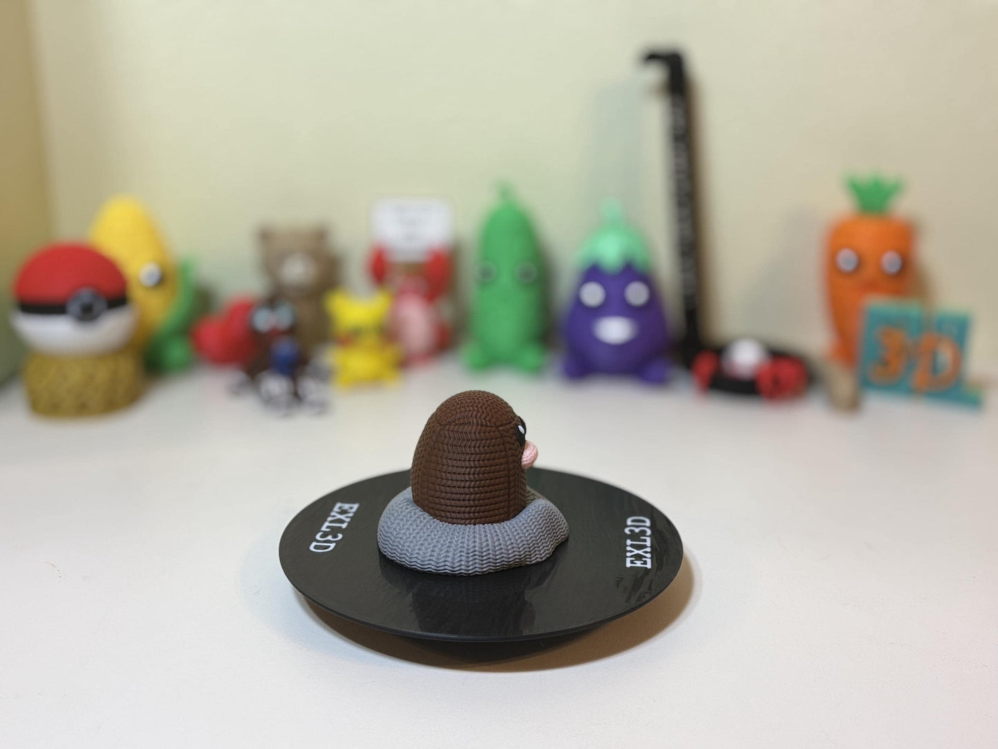 3D printed mole statue displayed on gaming setup shelf among pop culture decor