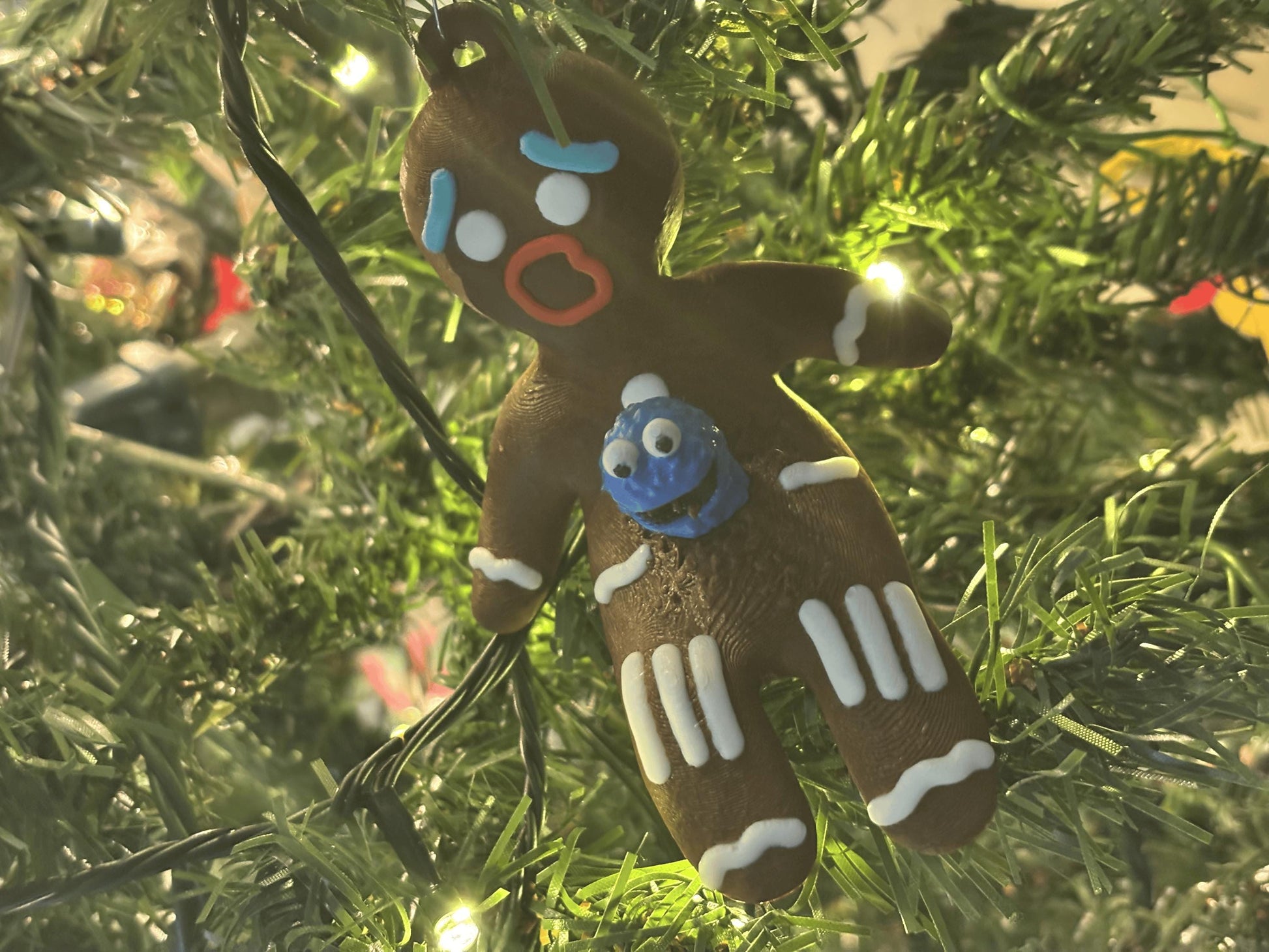Side angle of gingerbread chestburster ornament showing blue alien creature and PLA print texture