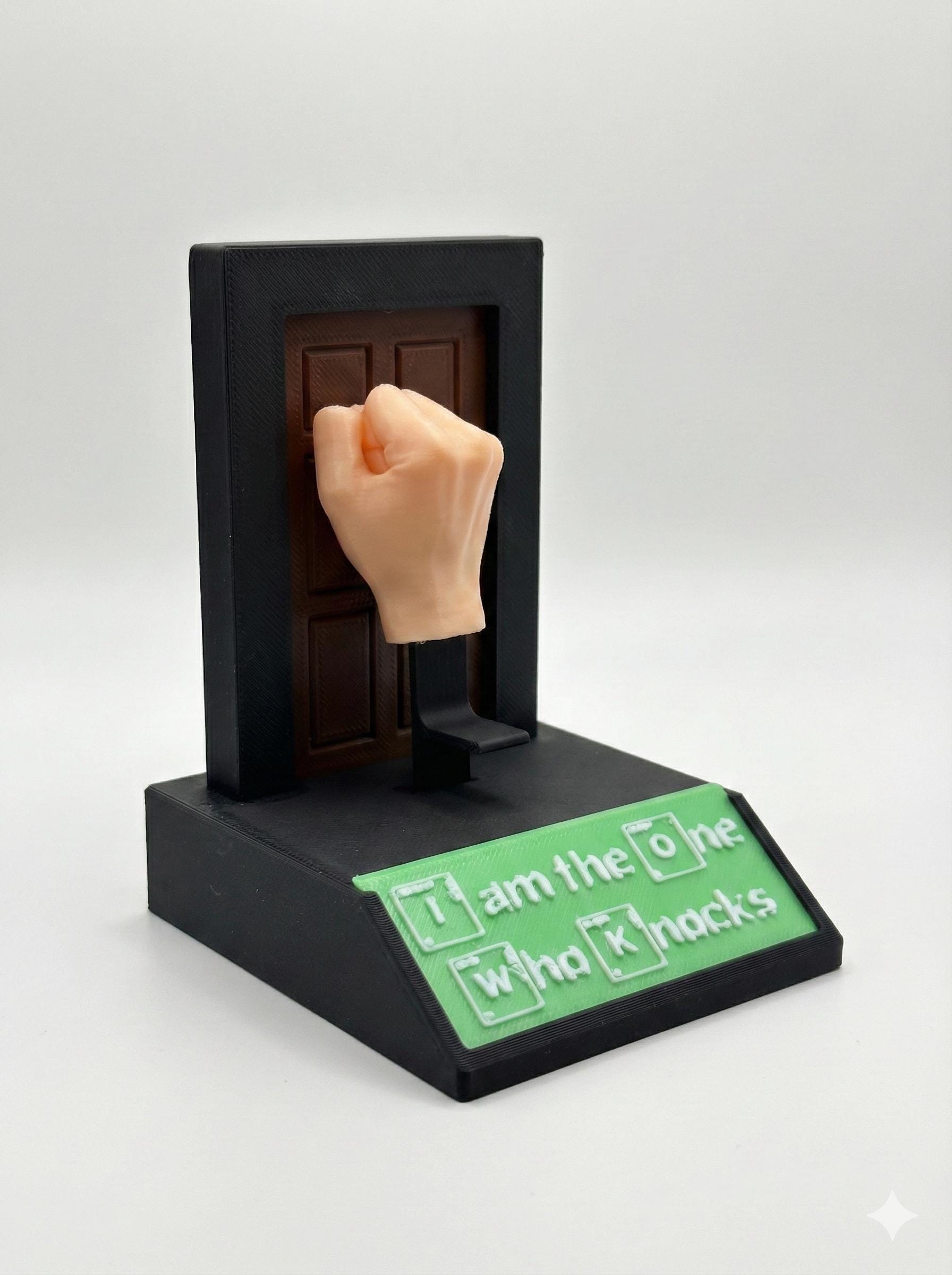 Kinetic fist toy beside monitor showing real desktop scale and footprint