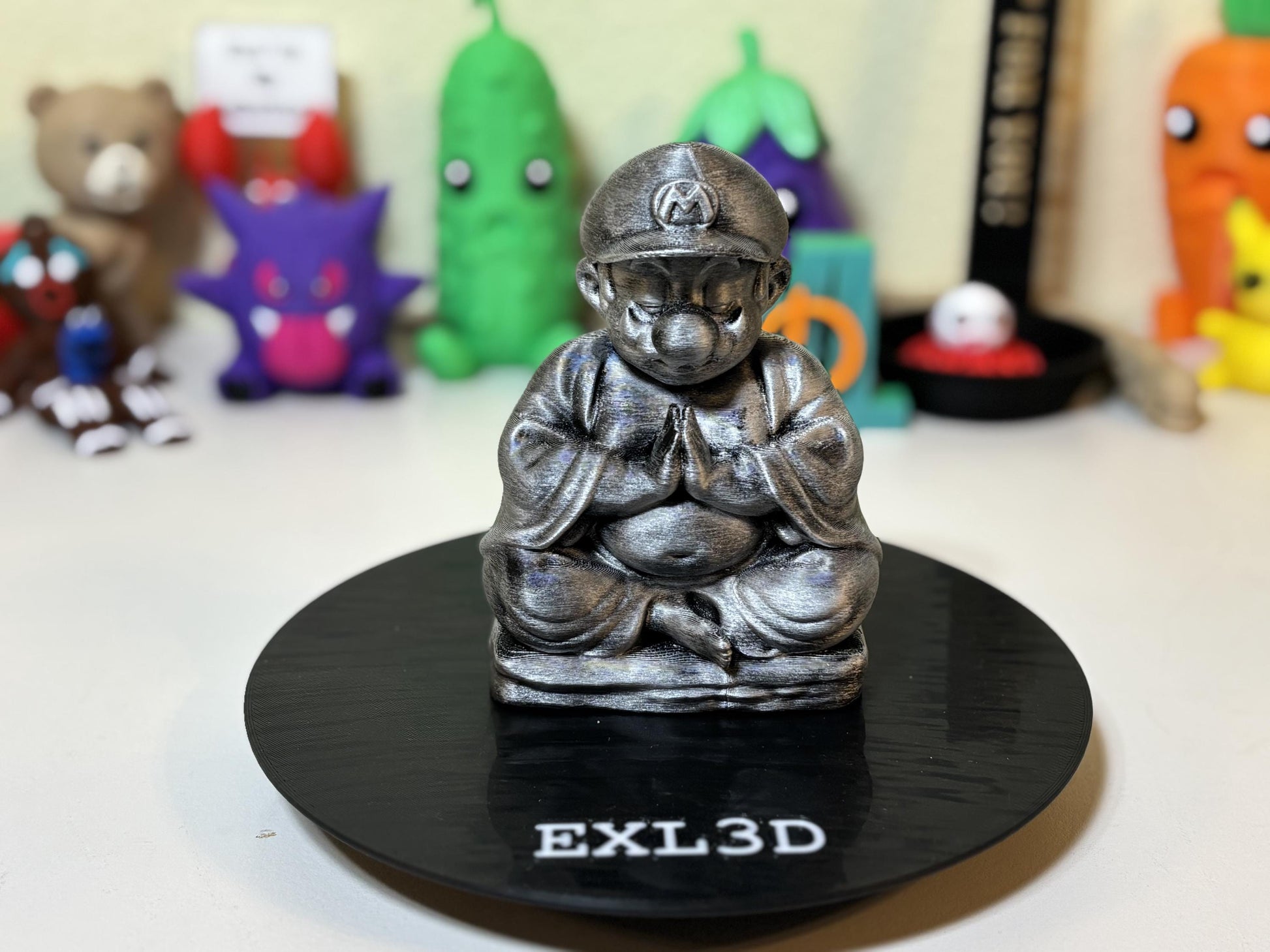 Side profile of matte black base zen plumber statue five inches tall
