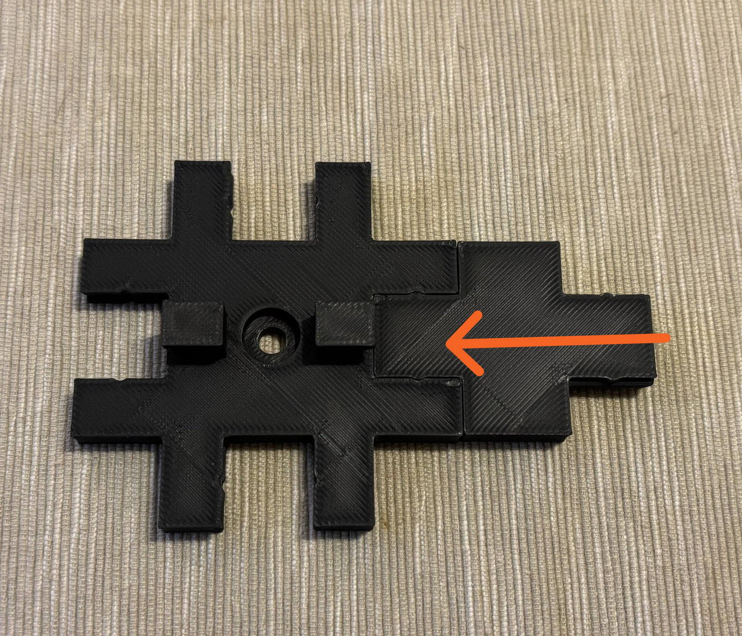 Close-up of geometric 3D printed wall tile showing crisp letter detail and finish