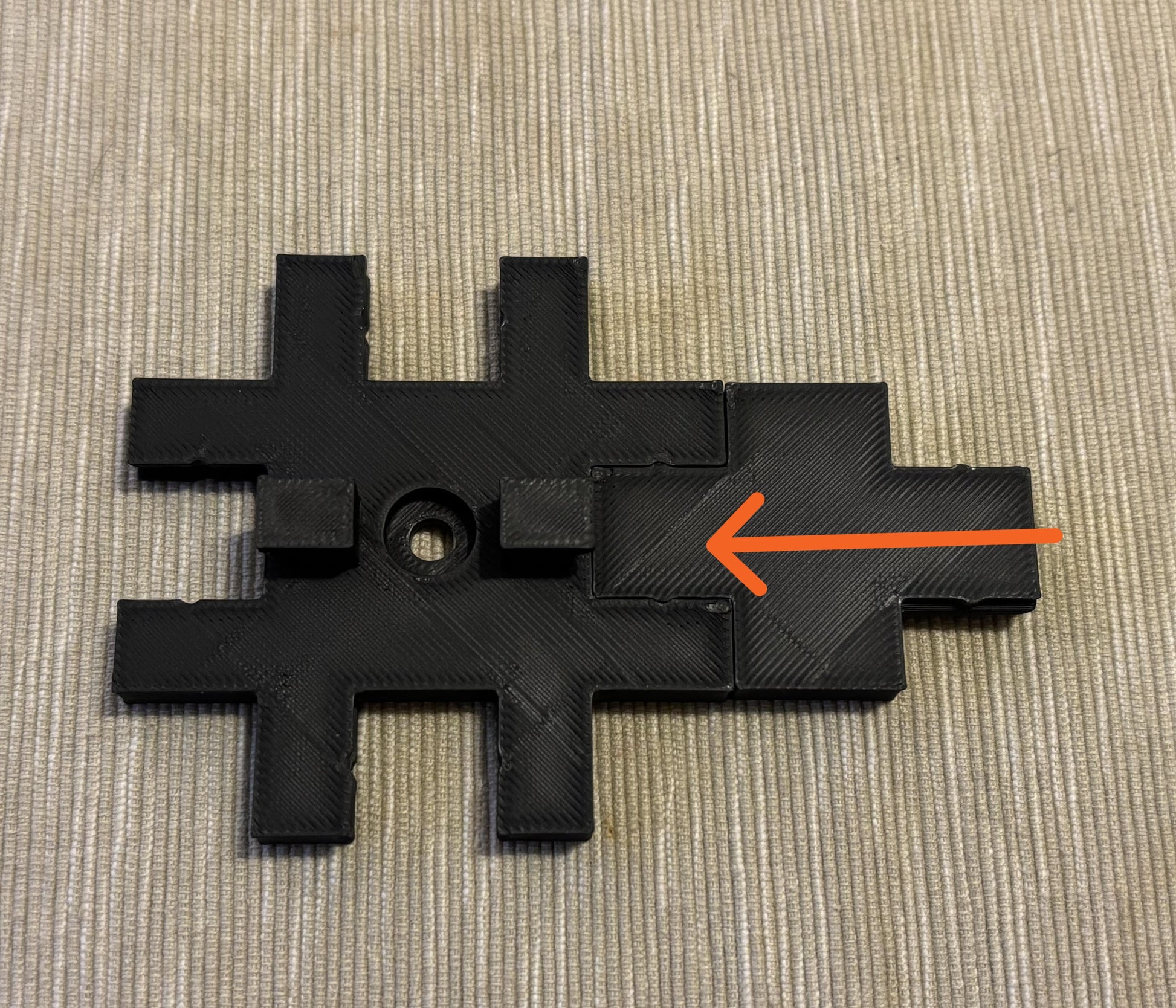 Close-up of geometric 3D printed wall tile showing crisp letter detail and finish