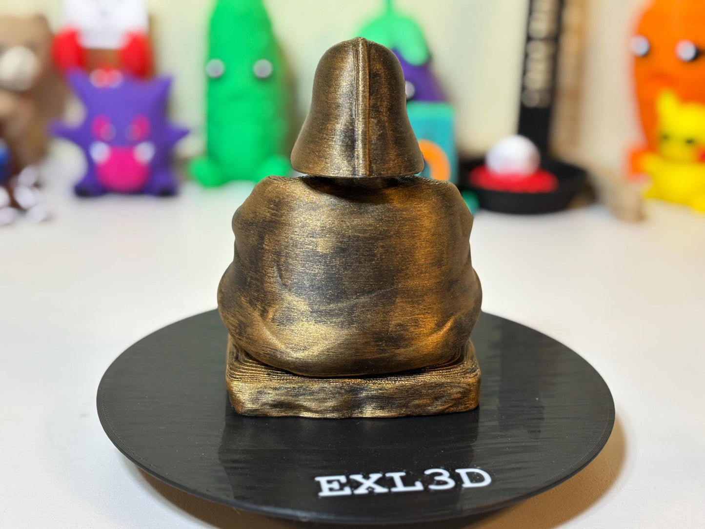 3D printed gold Buddha Vader statue styled beside monitor as desk decor accent