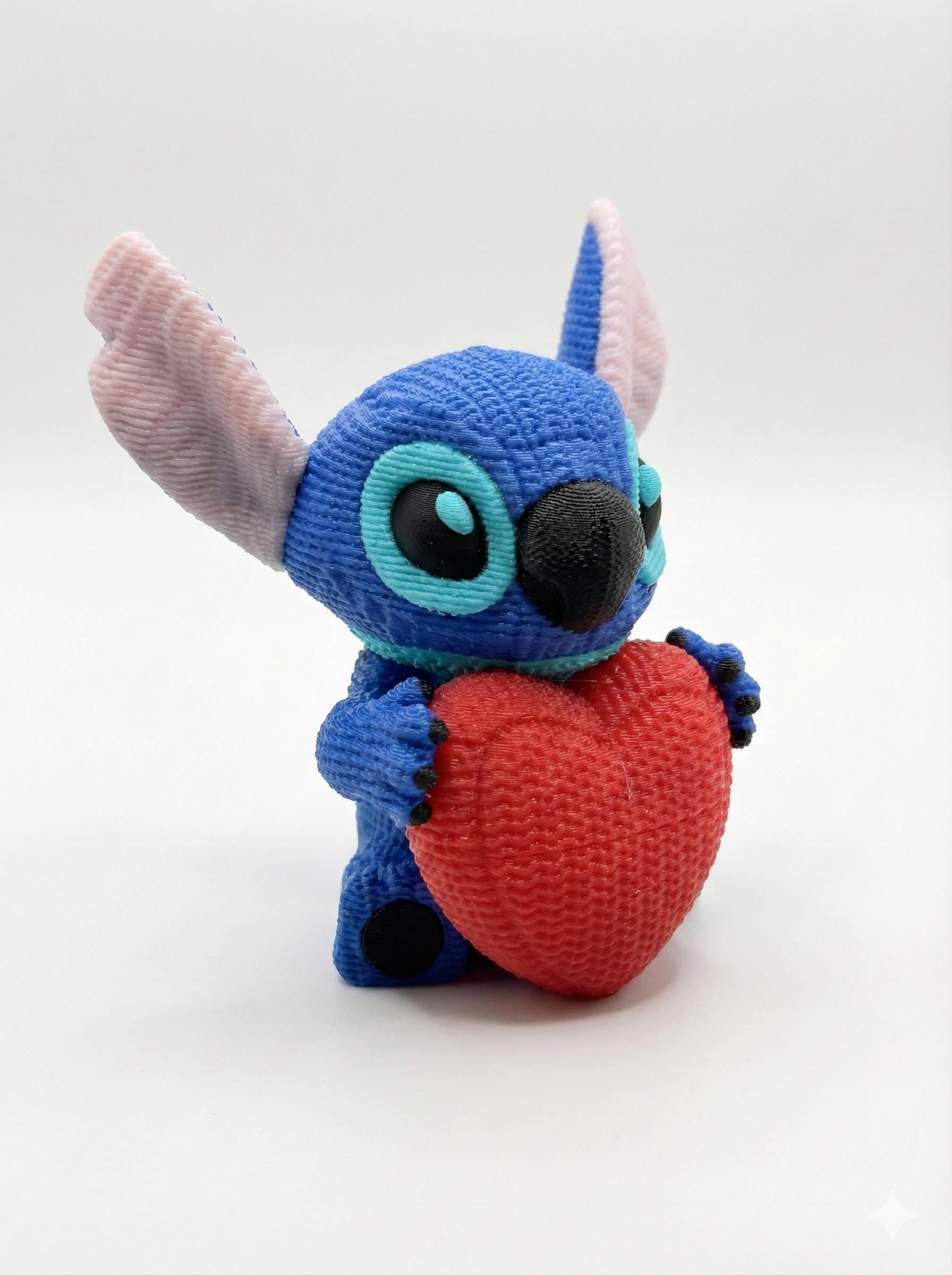 alien heart figure 3D printed desk decor displayed on bookshelf beside small plants