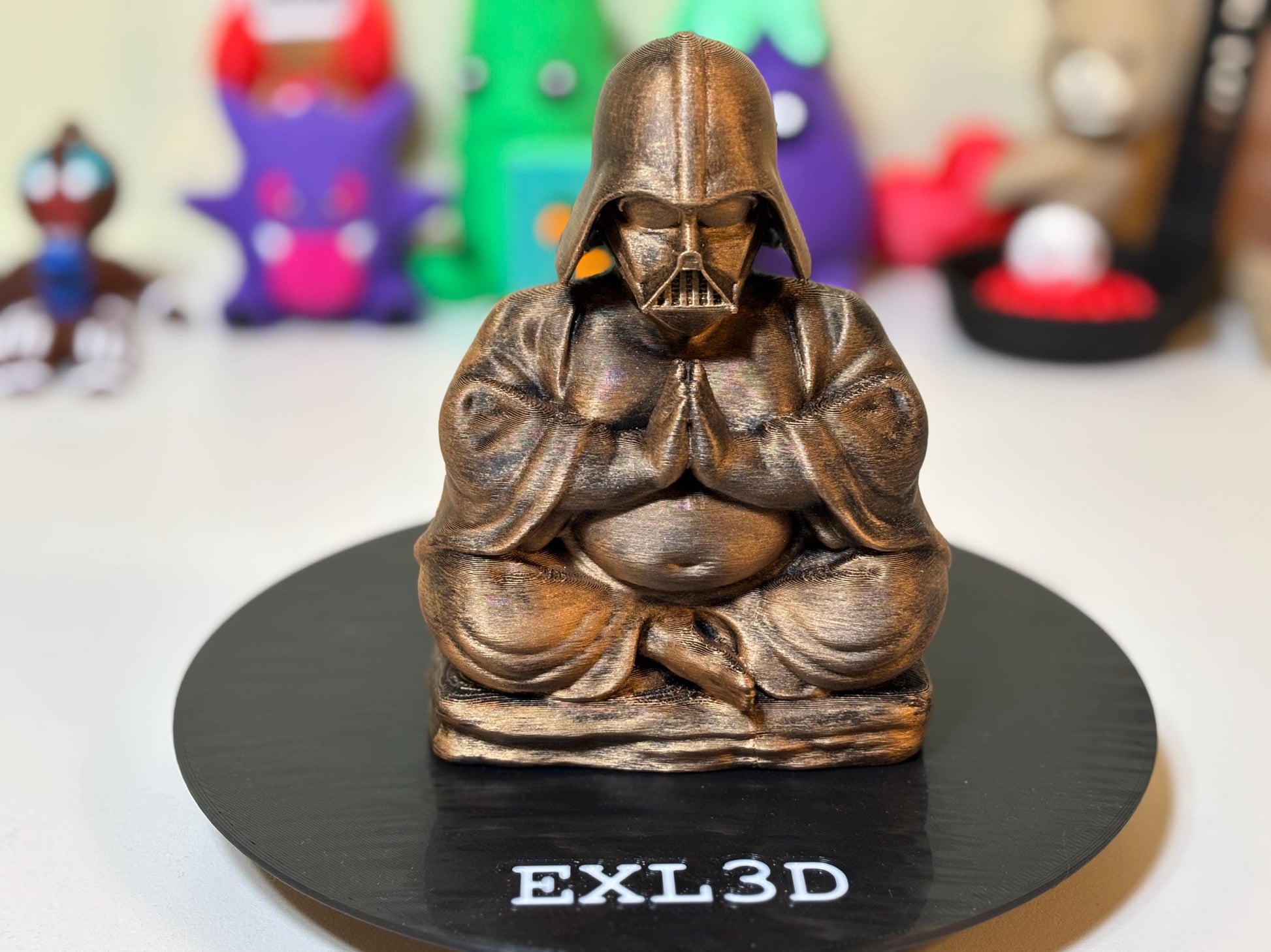 3D printed Zen Buddha Vader statue in bronze finish against a minimalist desk setup
