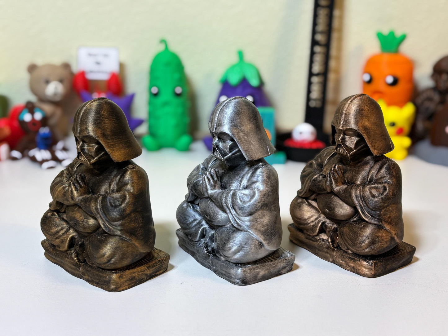 3D printed Buddha Darth Vader figurine in silver finish displayed on a desk