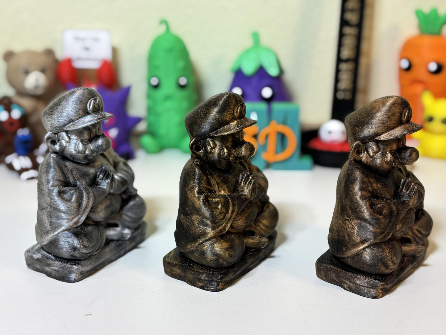 Silver 3D printed Buddha statue beside mechanical keyboard setup