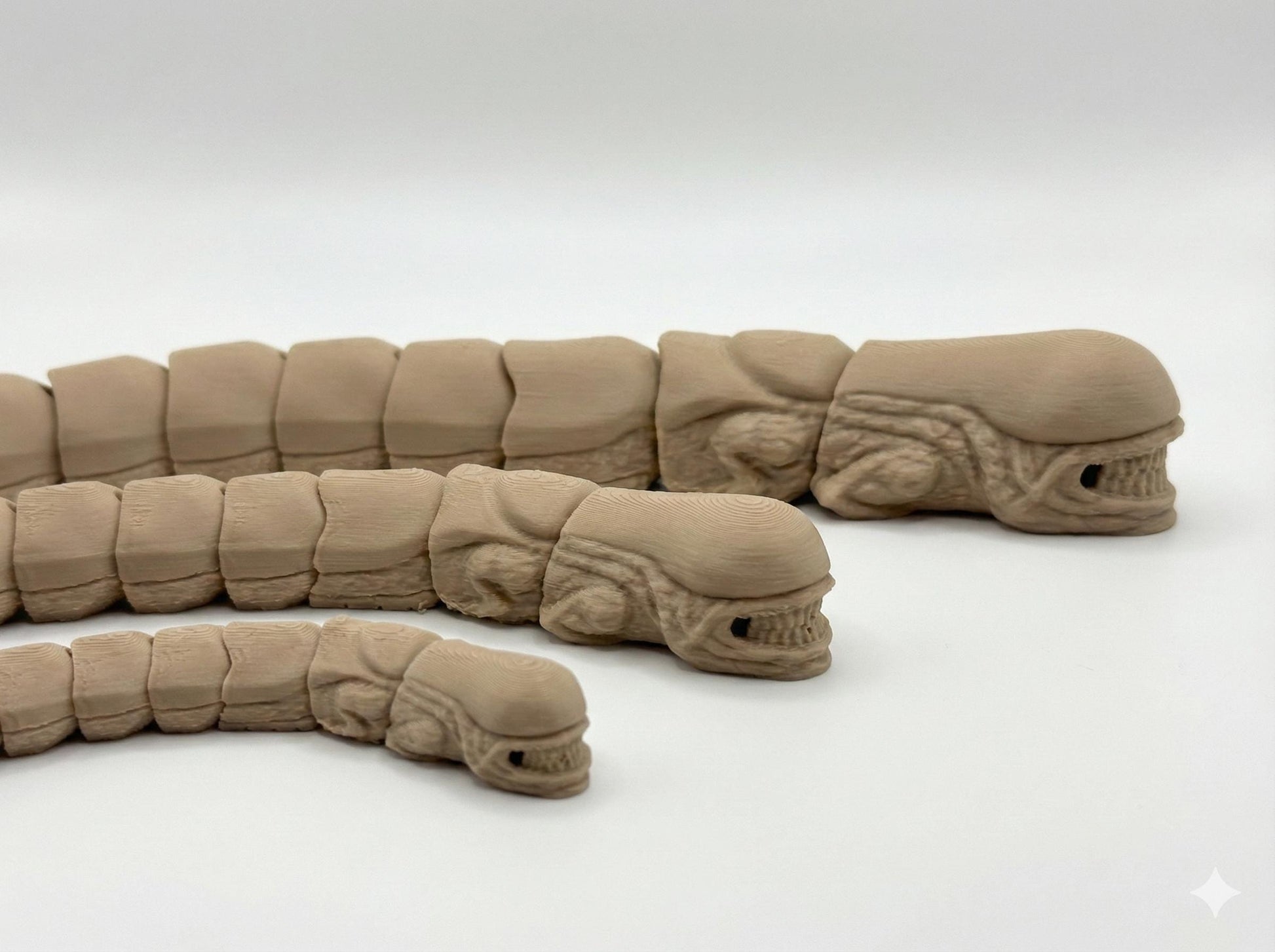 Small medium and large alien flexi toys shown side by side for size comparison