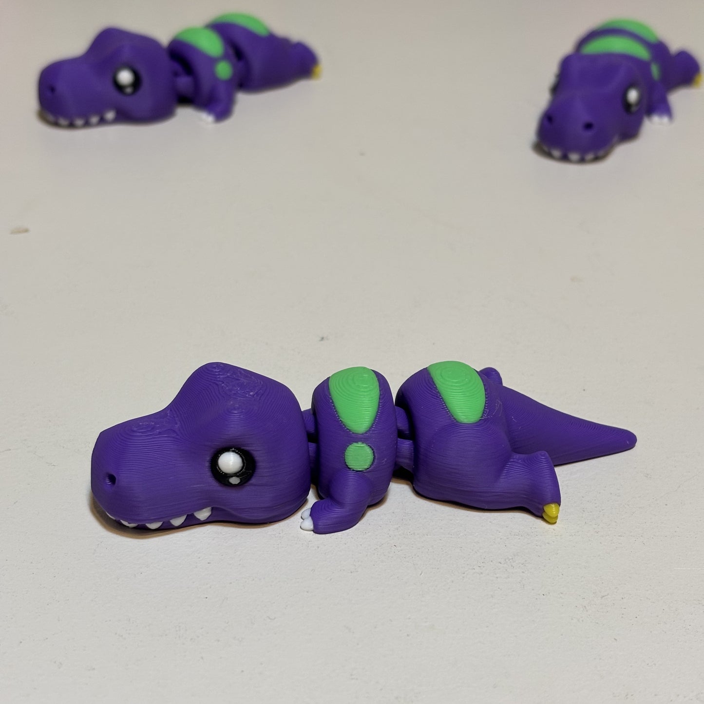 Fully jointed flexi dragon figurine in purple matte finish on shelf display