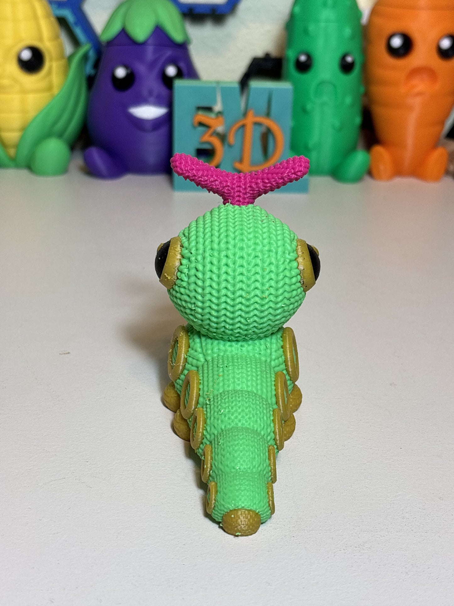 Caterpie faux knit figure beside everyday objects showing small display size
