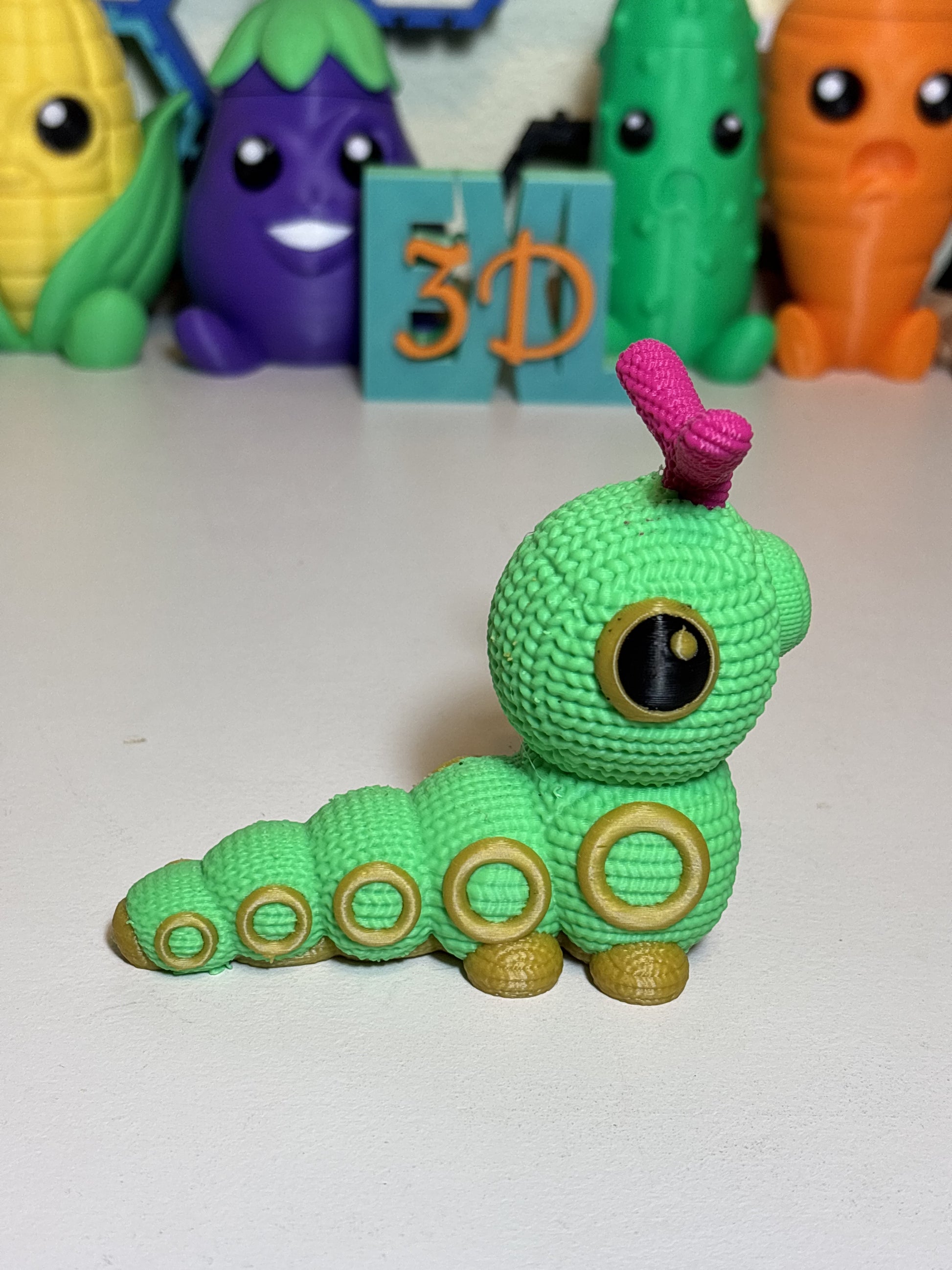 Side profile of 3D printed faux knit Caterpie collectible statue in natural light