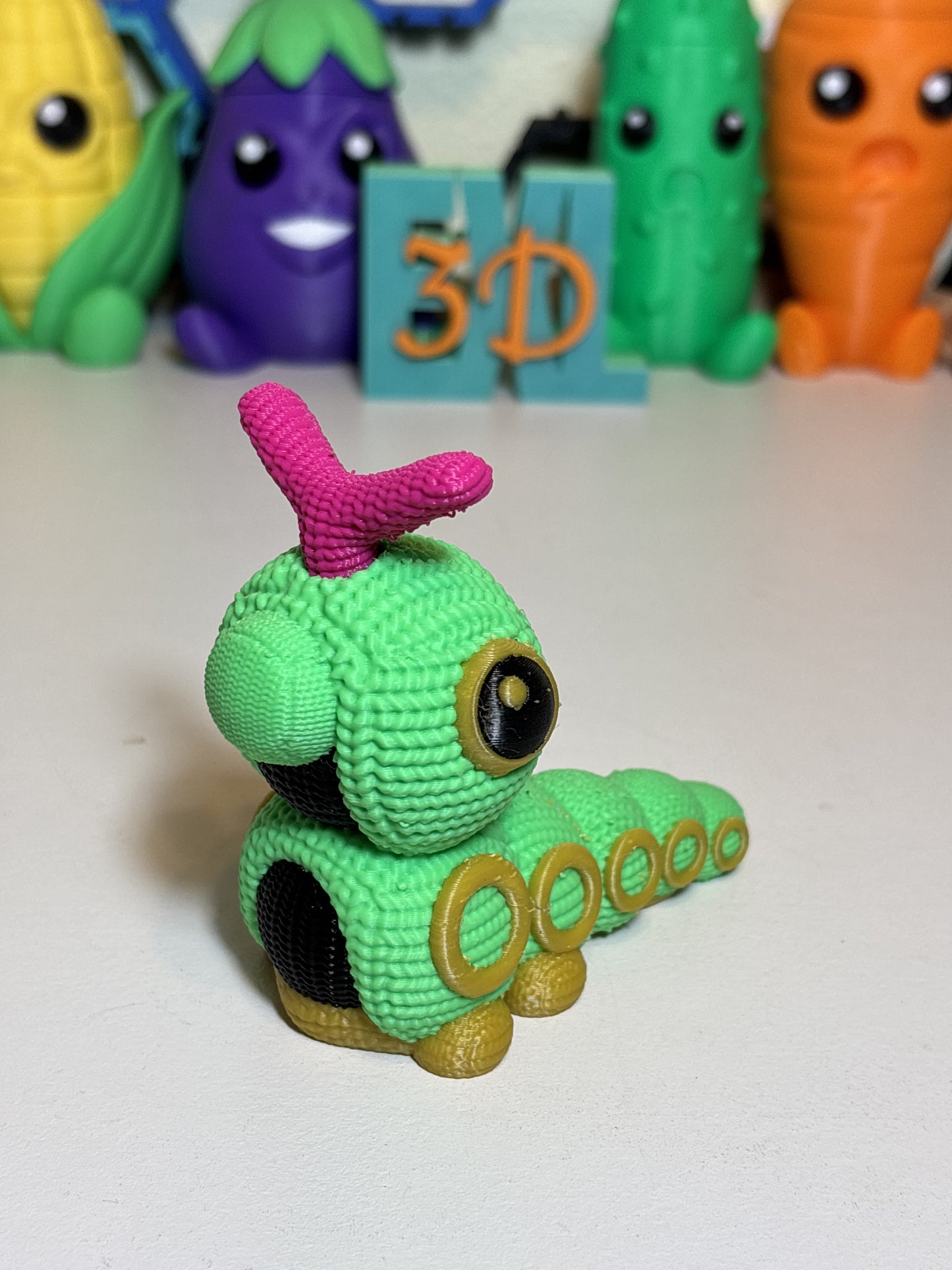 Faux knit Caterpie 3D printed figure displayed on wooden desk surface