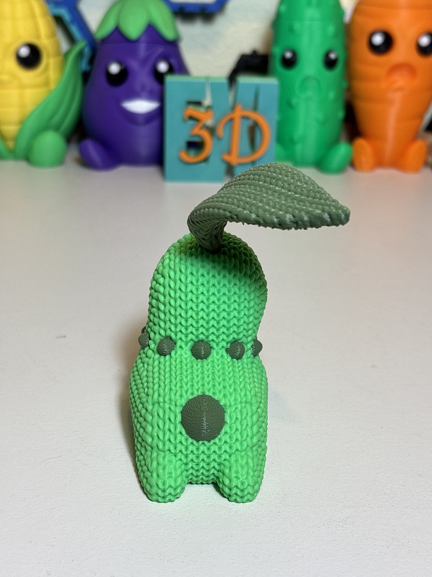 Side angle view of faux knit Chikorita sculpture showing full form