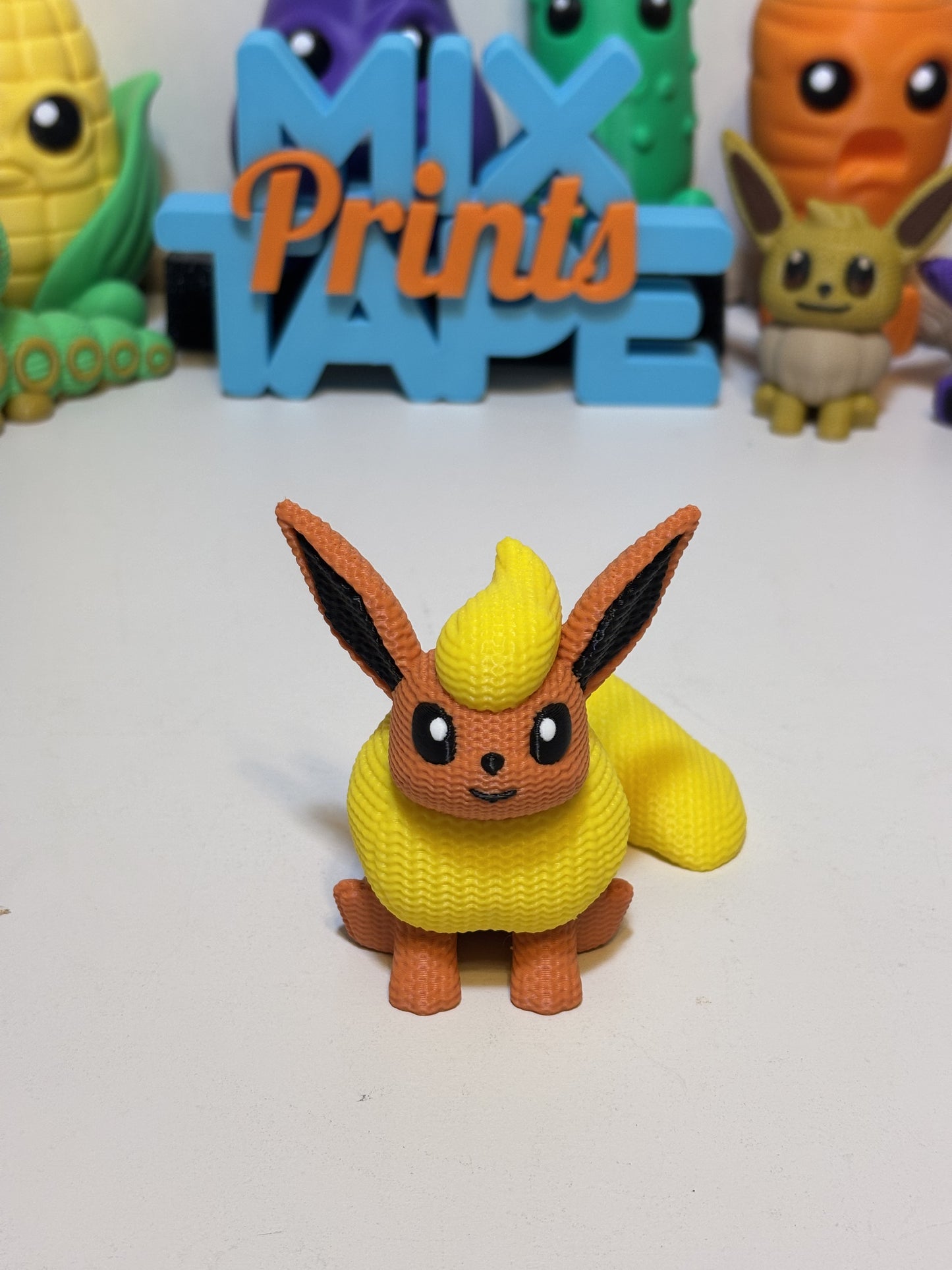 3D printed faux knit Flareon figure displayed on wooden shelf