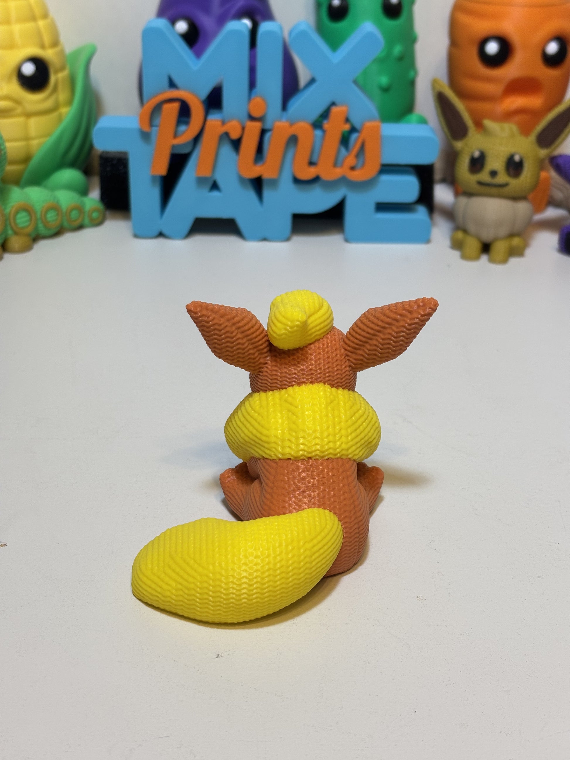 3D printed Flareon collectible figure styled on desk with plants