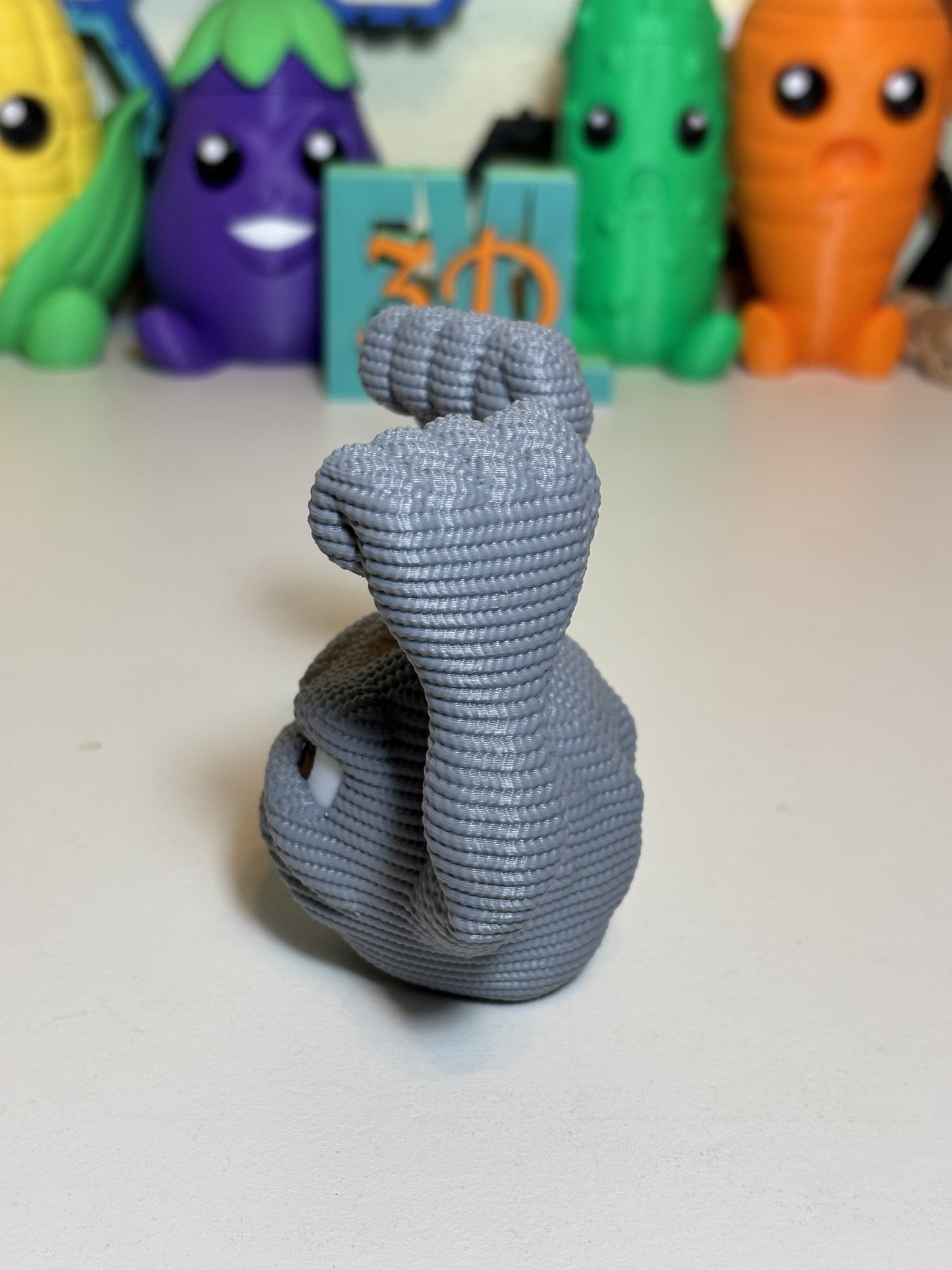 Side angle view of faux knit Geodude figurine showing full rock arm detail