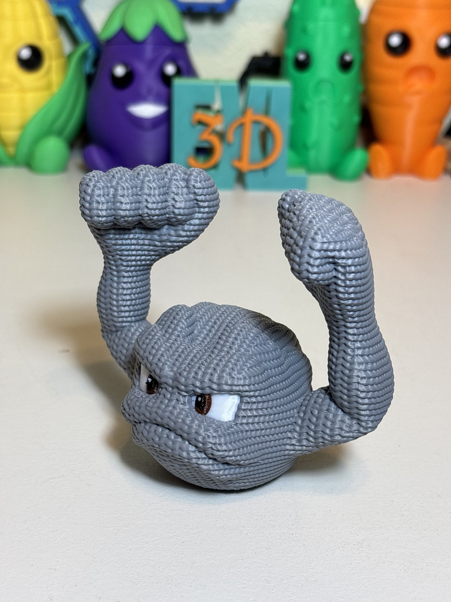 Faux knit textured 3D printed Geodude figure on wooden desk surface