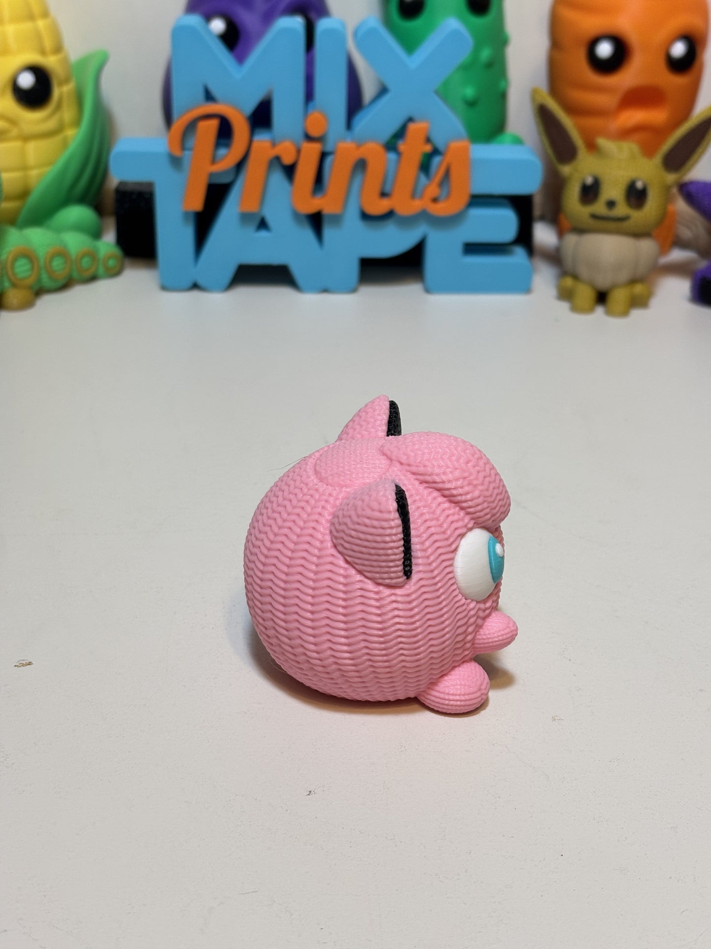 Side angle view of faux knit Jigglypuff figure showing rounded silhouette and finish