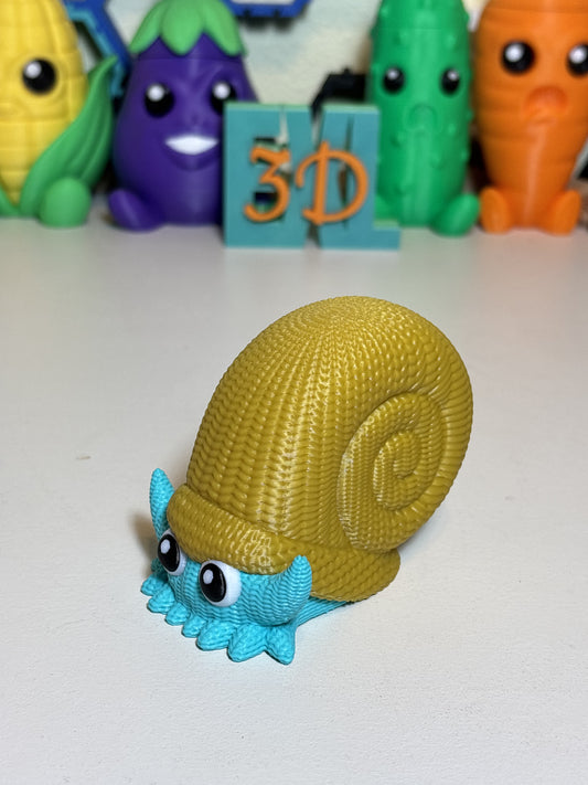 Faux knit 3D printed Omanyte figure displayed on a wooden desk