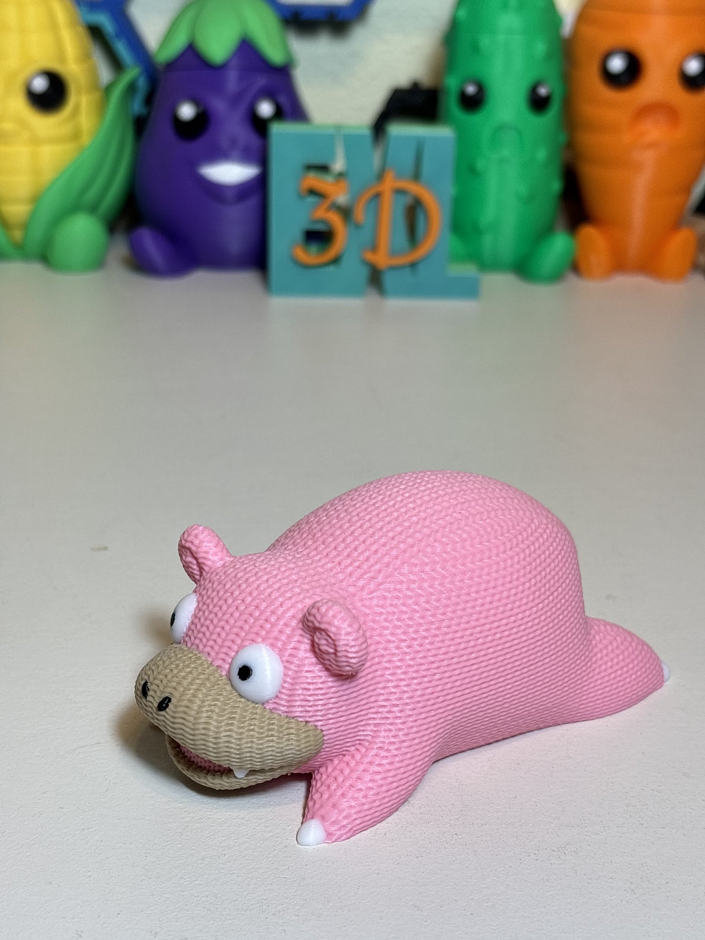 Faux knit SlowPoke 3D printed decorative statue on wooden desk