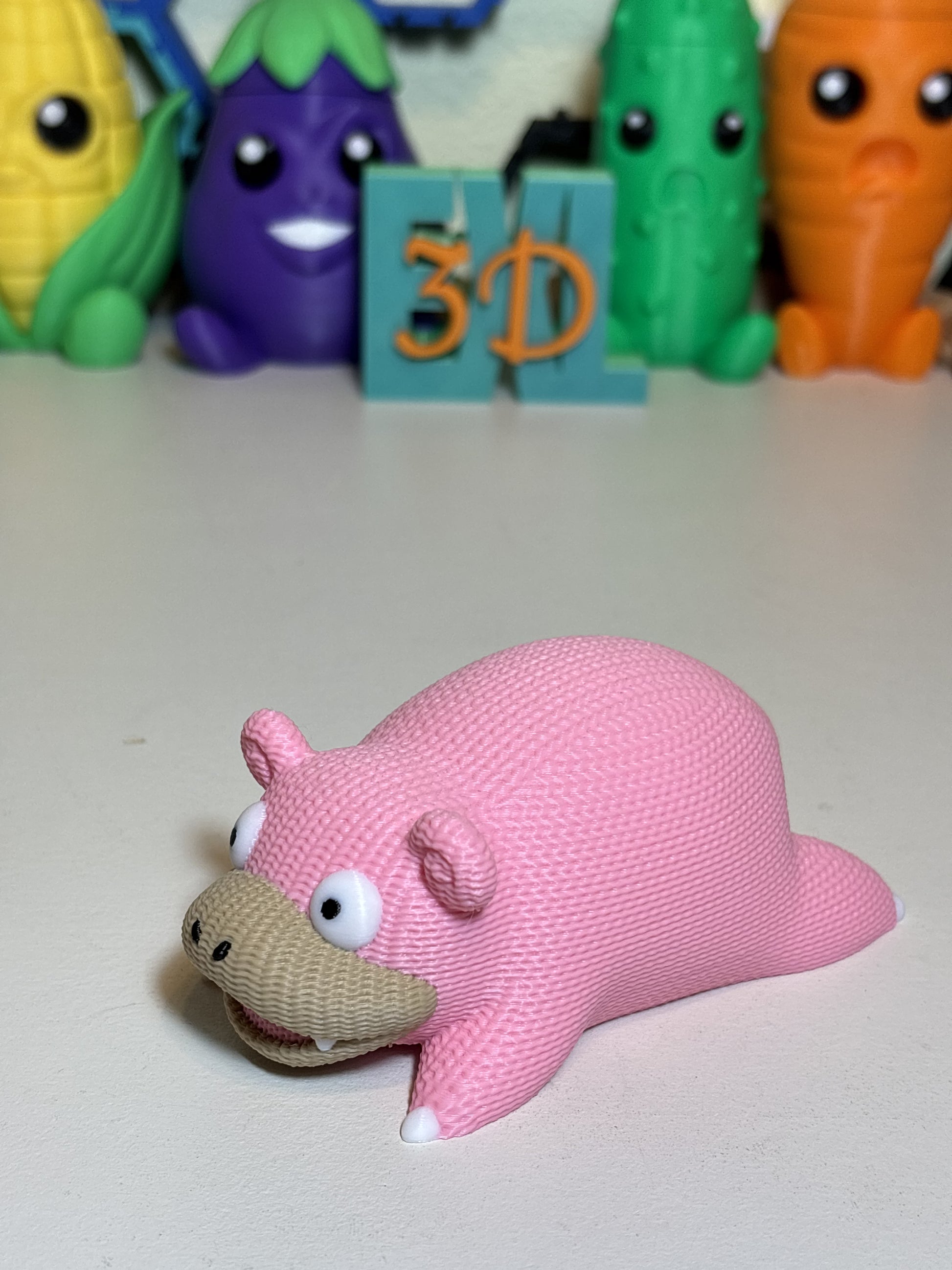Faux knit SlowPoke 3D printed decorative statue on wooden desk