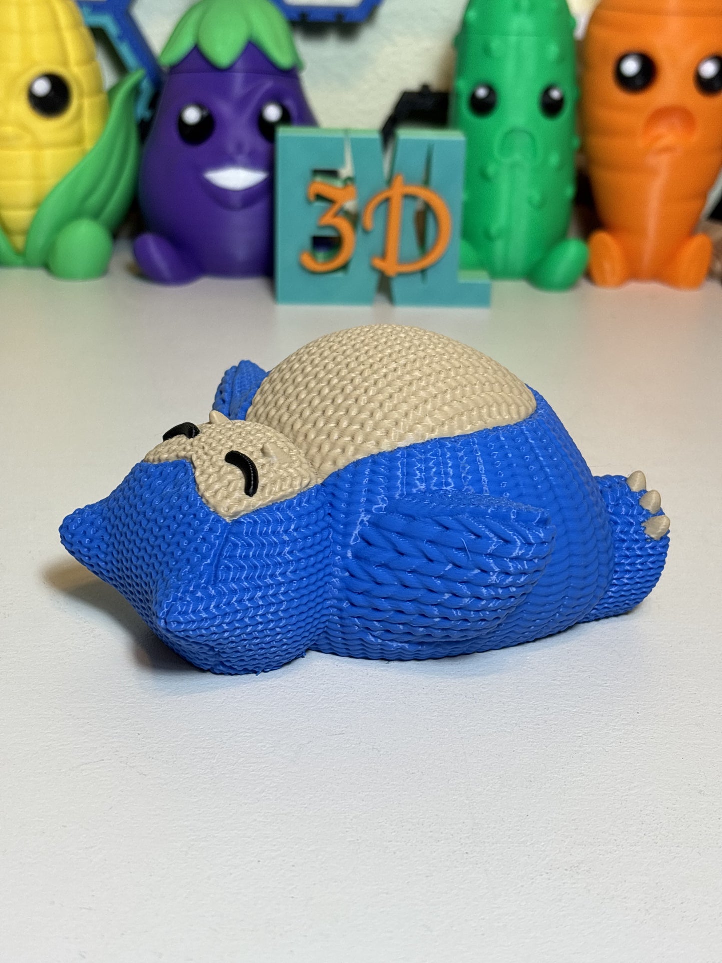 3D printed Snorlax figure with faux knit texture on wooden desk
