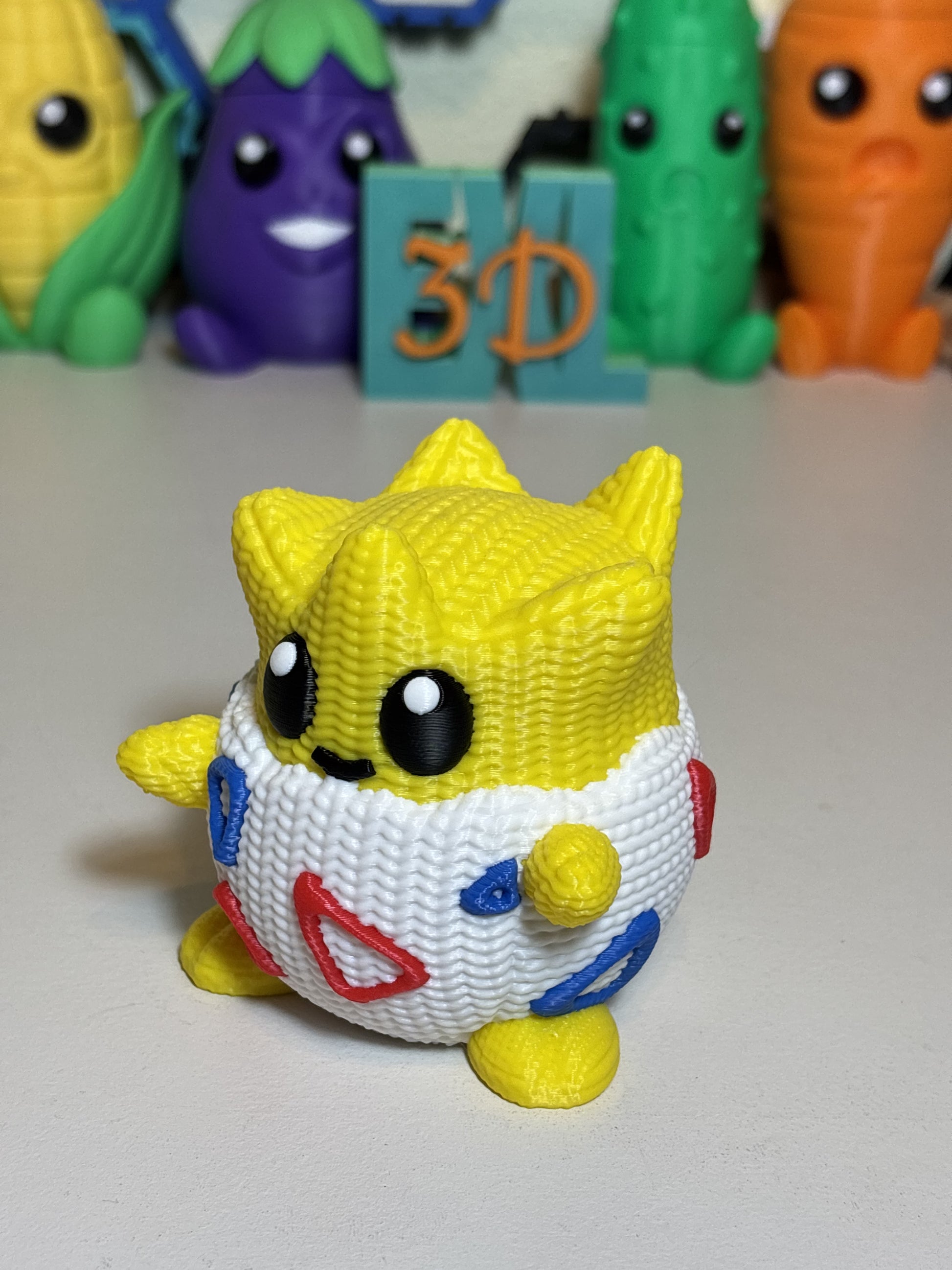 Faux knit 3D printed Togepi figure displayed on a wooden desk