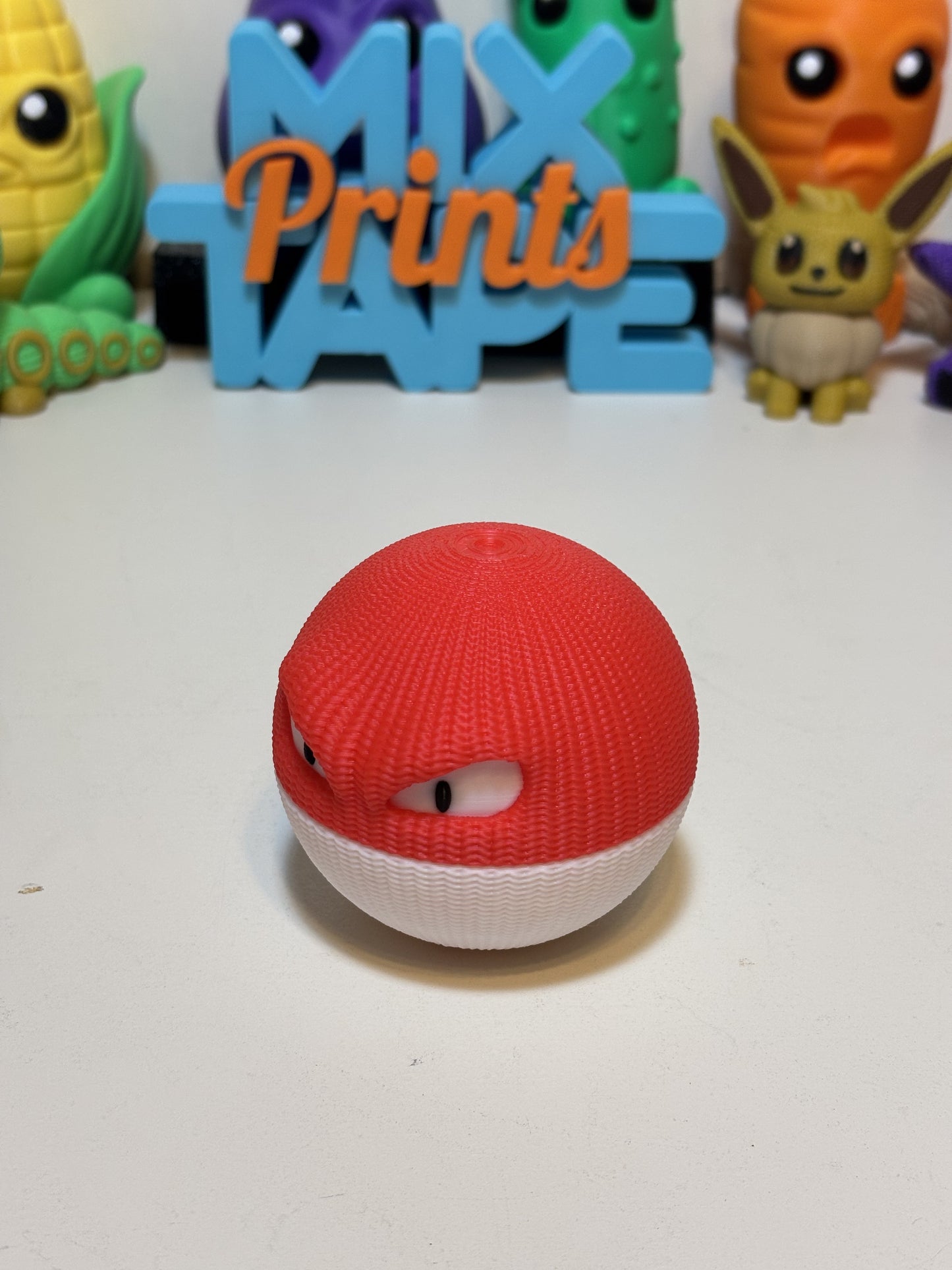 Faux knit Voltorb 3D printed statue displayed on wooden desk shelf